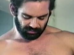 Hairy gay man strokes his big cock in retro fetish clip