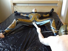 Latex Danielle is attached to the bed and also masturbated with the massage vibrator. Entire video