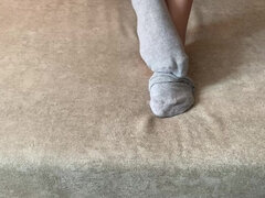 Girl Strokes Her Long Legs in Gray Socks