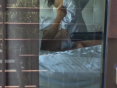 Filming a hot couple having sex while looking out the hotel window