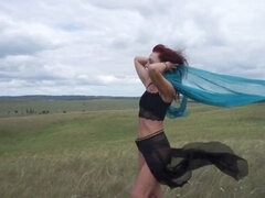 Mature exotic dancer enjoys windy weather atop a hill in Russia