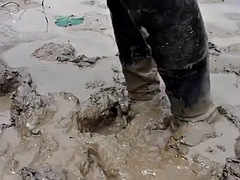 Two Thai men in high boots swim in the mud!